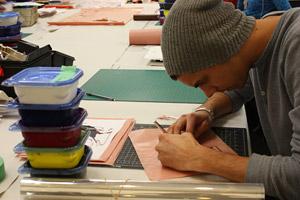 Young man drawing at a table.